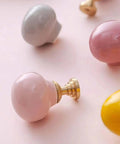 Totally Fresh Ceramic Ball Cabinet Knob Lemon Yellow Single Hole Drawer Pull For Bedroom Dresser And Kitchen Cupboard, shown with pink and gray knobs.