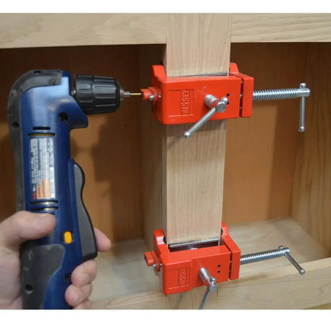 Cabinetry Face Frame Clamp For 1.5 To 2 Inch Stiles Keeps Stiles Flush For Drilling And Fastening Hardened Bushing Delivers Precise Holes Red Heavy Duty Workhorse Clamp For Easy Secure Frame Alignment in use with a drill.