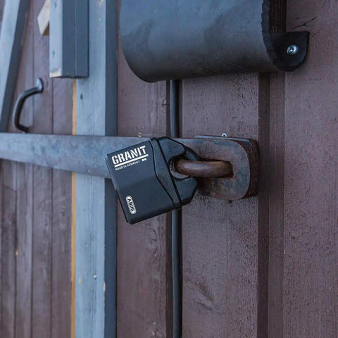 Granit Alloy Steel Padlock With Beefy Hardened Shackle Keyed Different High Security Lock securing a wooden gate.