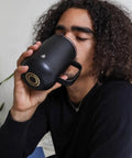 Self Heating Coffee Mug With Rechargeable Battery And Digital Temperature Control Keeps Your Drinks Piping Hot All Day Long Sleek LED display mug being enjoyed by a person.