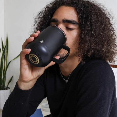 Self Heating Coffee Mug With Rechargeable Battery And Digital Temperature Control Keeps Your Drinks Piping Hot All Day Long Sleek LED display mug being enjoyed by a person.