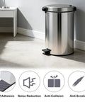 Front view of a stainless steel pedal trash can with a black foot pedal in a bright room.