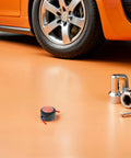 Low Key No Stress Automatic Aerosol Fire Extinguisher 2 Pack on garage floor next to car wheel and tools.