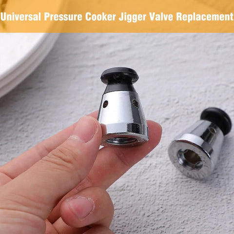 Chrome pressure cooker jigger valve replacement held in hand; black rubber cap and chrome body with vent holes.