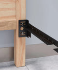 Close-up of Tough As Nails Bed Frame Footboard Extension Brackets set on a wooden frame, designed for easy assembly.