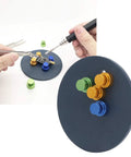 Hands using Magnetic Welding Bracket Soldering Holder For PCB Boards with colored magnets on a metal base.