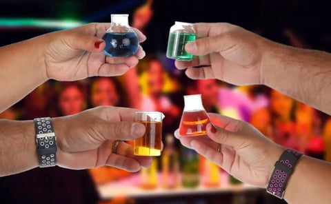 Hands holding mini beaker and flask shot glass set with realistic lab markings, perfect gift for chemistry and bio grads, 4 assorted.