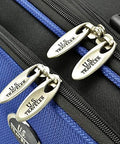 Blue U.S. Traveler rolling luggage close-up with three silver zipper pulls labeled U.S. Traveler.