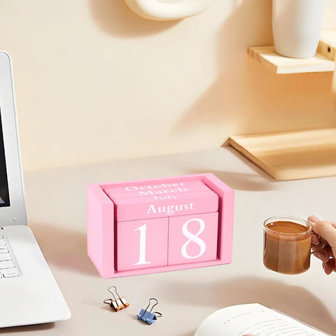 Pink Decor Wooden Desk Calendar Blocks Perpetual Block for Office on a desk with a hand holding a coffee cup