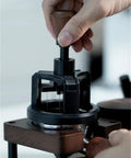Hit The Mark Every Time With This Rock Solid 58mm Magnetic Stirrer For Espresso Portafilter in use with wooden handle.