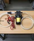 Heavy Duty Commercial 12V Electric Fluid Transfer Pump For Oil And Gasoline with wiring and tubing on wood surface.