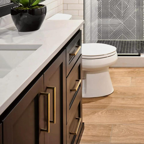 Modern bathroom featuring dark cabinetry with 5 Inch Antique Brass Cabinet Pull Handles, 6 Pack, Grooved Texture Non Slip Grip.