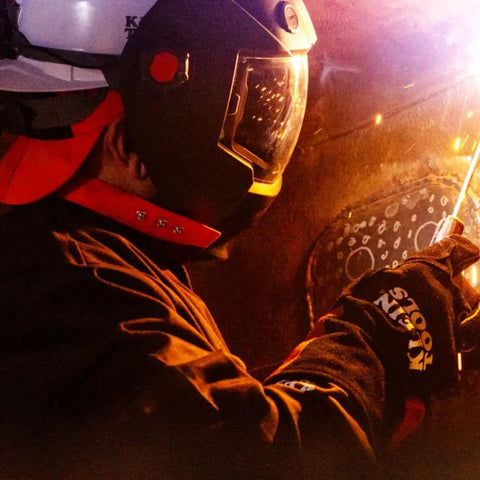 Welder using flame resistant welding cap with wide neck bill, sweat absorbing padding, for sparks and spatter protection.