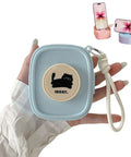 Badass Hella Tough Shockproof EDC Case For Bluetooth Headphones in hand, light blue, with cute cat design and wrist strap.