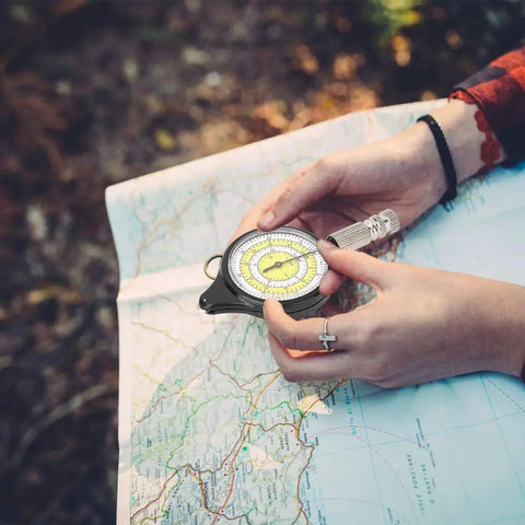 Wicked Compact Map Measure Wheel And Ridiculously Light Distance Calculator For Hiking Camping Trekking Trail Running And Road Trips Sleek Navigation Gear held above a map.