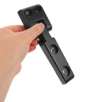 Hand holding heavy duty dual joint forklift hood hinge kit for industrial engines, bolt on installation, black metal.