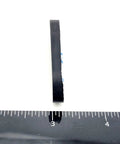 Side view of 2 Inch By 3/4 Inch Oval Silicone Bumper Feet 3/16 Inch Thick with ruler for scale, showing adhesive backing.