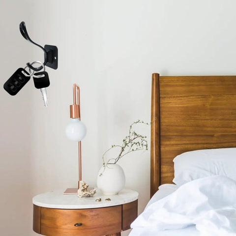 Vintage Matte Black Wall Hooks Set Of Five For Hanging Heavy Coats Umbrellas And Handbags Boasts Dope Industrial Vibes And Rock Solid Screw Mount Hardware with keys on it by a bedside table.