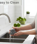 Person washing Garlic Peeler Attachment For Cylindrical Electric Meat Grinders under a kitchen tap, displaying easy cleaning