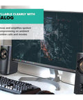 T60 Compact 2.0 Desktop Speaker System Black For Crisp Stereo Sound On Your PC next to monitor with green plant