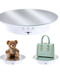 Hassle Free Rotating Display Turntable Stand For Jewelry And Watches 7.87 Inch white USB rotating platform showing a teddy bear and handbag.