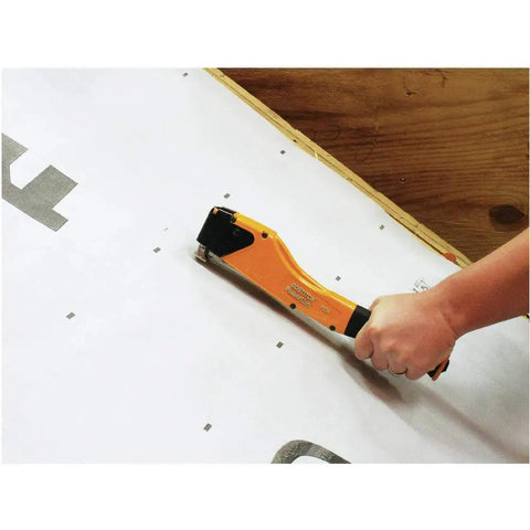 Person using Workhorse Hammer Stapler For Construction With Long Reach Knuckle Saver Handle And Non Slip Grip on insulation