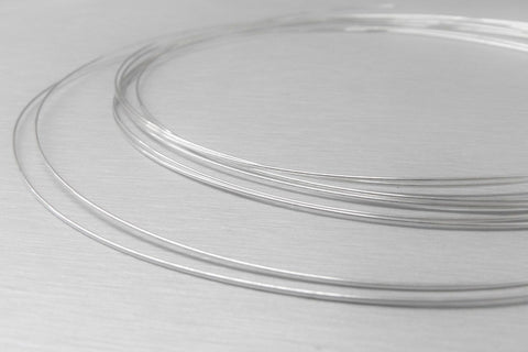 No Hassle Pro Grade Easy Flow Silver Solder Wire For Jewelry Making And Repair, thin coils of soft silver wire on a surface.