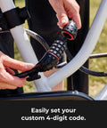 Hands setting a 4-digit combination on a Bike Cable Lock 6 Feet By Half Inch With Resettable Four Digit Combination And Black Vinyl Coating