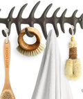 Heavy Duty Cast Iron Wall Hook Rack Featuring A Badass Fish Bone Skeleton Layout With Four Chunky Rustic Hooks and mounted towels and tools.