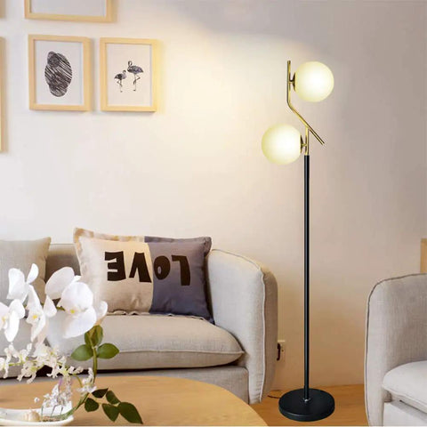 Two Milky White Glass Orbs Brass Finish Floor Lamp With Black Base, Modern Mid Century Style in living room setting