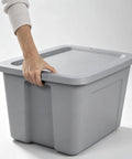 Person holding the handle of a Heavy Duty 30 Gallon Plastic Storage Bin With A No Hassle Snap Closure built tough.