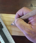 Person using aluminum handle ruler for precise cuts, 55cm centimeter ruler with dual-sided CM markings on wood surface
