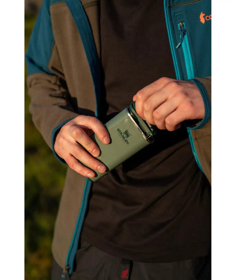 Person holding 8 Oz Insulated Wide Mouth Hip Flask With Leakproof Hinge Cap That Never Loosens Pocket Friendly Stainless Steel Liquor Container BPA Free Rust Proof On The Go Portable Design For Easy Carry And Everyday Adventures outdoors.
