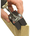 Using Pro Grade DrillBlock Drilling Guide for precise hole in wood with solid metal drill jig, six diameters, V-grooves, nonslip grip.