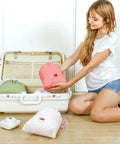 Woman packing Waterproof Drawstring Storage Bags Set Of Five Made From PE Plastic Great For Travel Gym Swim Gear And Laundry Organization Into Suitcase