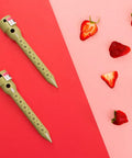 Top view of Super Handy Eight Inch Deep Root Watering Stakes Four Pack In Tan placed next to strawberries on a pink surface.