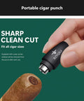 Cigar punch tool by ROYGRA, stainless steel with black housing, close-up used on a cigar.