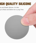 Silicone Door Stopper Bumper Pads With Strong Adhesive, close-up of a grey pad held by fingers, highlighting quality material.