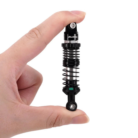 Hand holding 90mm Dual Rate Spring Oil Shock with CNC aluminum shock bodies and nylon bottom rod ends for TRX4 SCX10 1 by 10 RC Crawler.