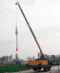 Dual-hook lifting chain sling with red hooks hanging from a blue/orange telescoping crane boom on a mobile crane truck.