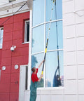Person using Heavy-Duty Commercial Extension Pole Delivers 4.5 To 18 Ft Reach For True Two-Story Access Up To 24 Ft Total on building