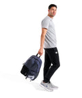 Man holding Do It All Swim And Sports Backpack 30L Navy Blue For Men And Women Multisport Daypack With Top Loading Main Compartment Wet And Dry