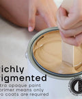 Stirring All-In-One House And Furniture Paint Matte Finish Palma Green No 51 1 Quart in a can with a stick.