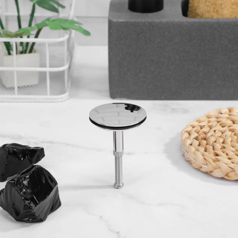 Rotary Bath Tub Plug Drain Stopper for Bathtub Overflow Cover in chrome finish, resting on a marble surface with natural decor.