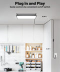Four Pack Linkable LED Shop Lights With Built In Outlet 100W 15000LM Aluminum Garage Lighting installed in workshop ceiling.