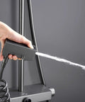 Handheld sprayer in use, part of UMJIGF Shower System Thermostatic 4-Function Shower Faucet Set, ergonomic design.