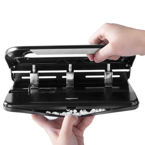 Hands using semi adjustable three hole punch for busy desks 30 sheet capacity black heavy duty paper punch for quick clean holes