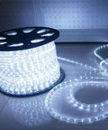 100ft 720 LED Rope Lights Low Voltage 24V Waterproof for Indoor Outdoor Lit Mood Lighting on Trees, Bridges, Eaves, Pools, and Weddings White Energy Efficient Safe for Kids and Pets reel of white LED rope lights glowing on floor