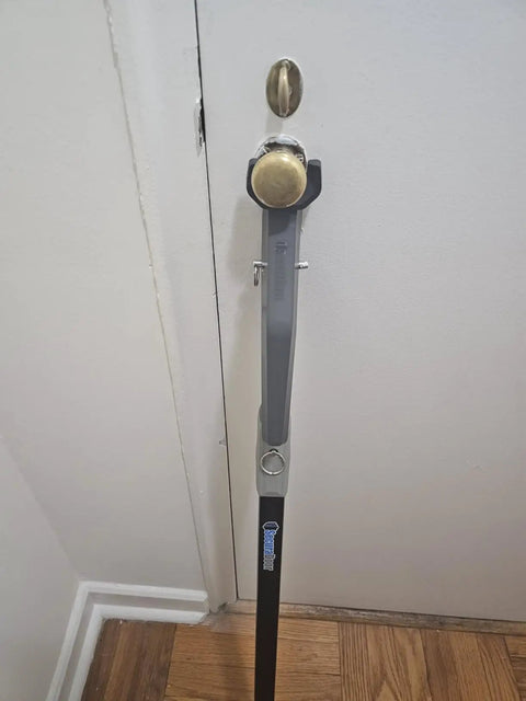 Heavy Duty Door Security Bar With One Ton Strength installed on inward-opening door, adjustable aluminum jammer for security.