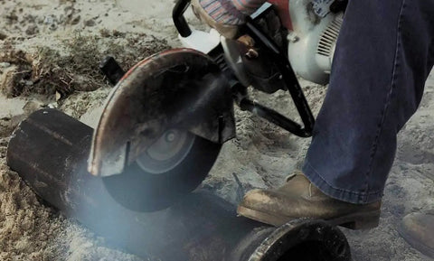 Person using Portacut High Speed Cutoff Wheel Type 1 Round Hole Aluminum Oxide on steel pipe with power saw on job site.